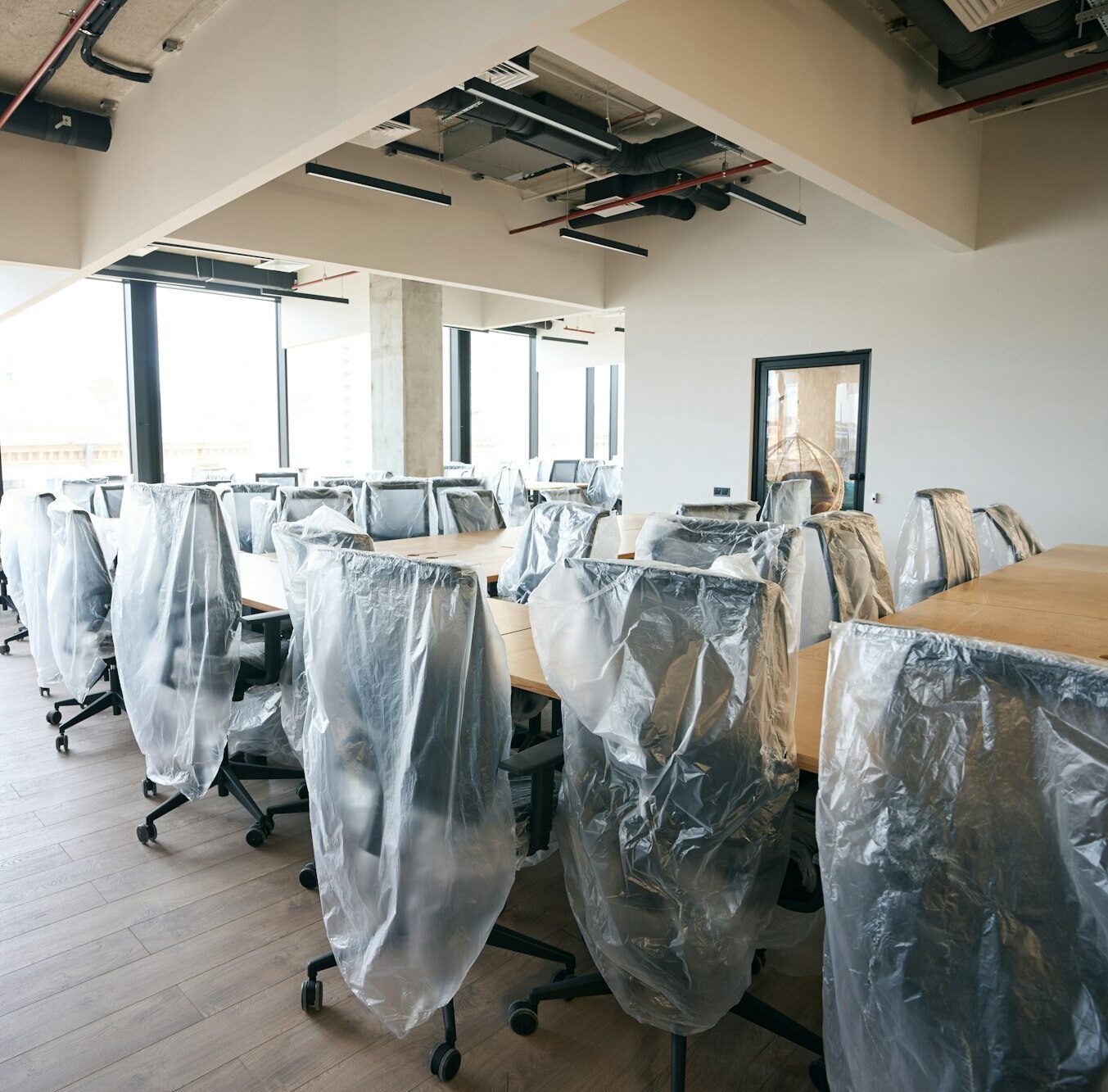 Coworking area after general cleaning, clean room with covered furniture